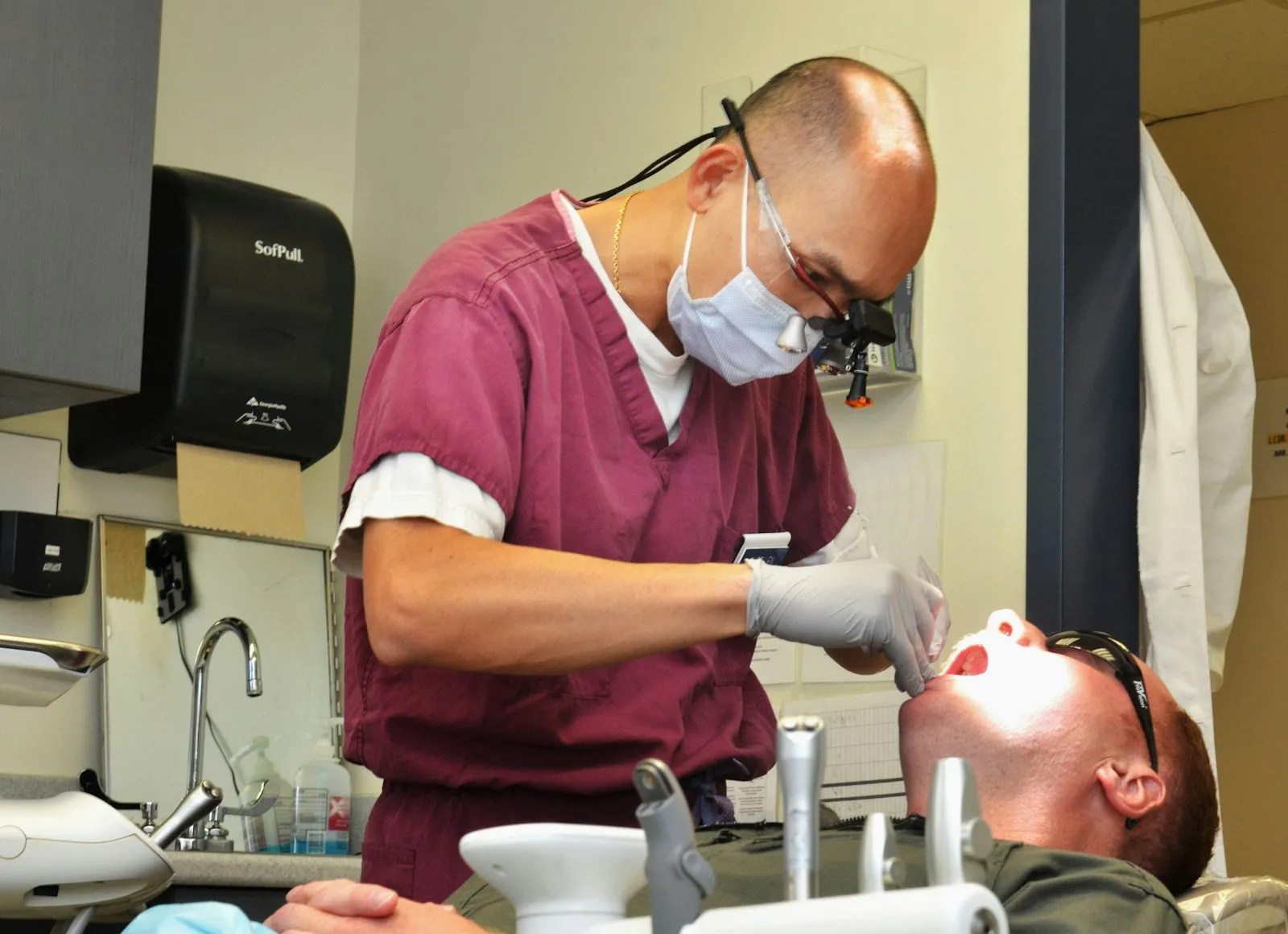 A dentist using magnification loupes during a precise procedure
