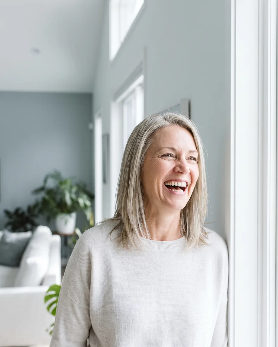 Crowns & Veneers in Dundee, MI. A woman laughing freely and unguardedly in a bright room.